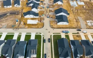 Federal Reserve Rate Cut: Impact On Housing Market 7 Aerial view of a suburban development with houses in various construction stages