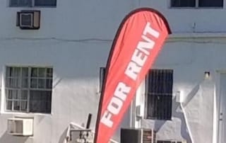 Red "for rent" flag in front of residential building