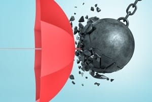 A large black wrecking ball collides with a red umbrella, symbolizing resilience in protection.