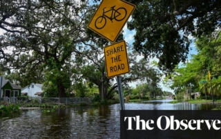 A flooded street in florida with road signs and houses in the aftermath of hurricanes