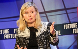 Woman in black and white checkered jacket speaking at a fortune magazine event