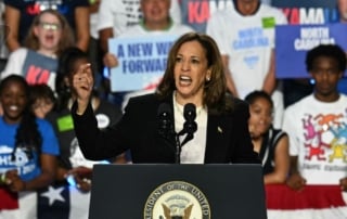 A woman passionately speaking at a podium at a political rally