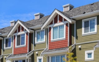 A row of contemporary multi-story townhouses with gabled roofs