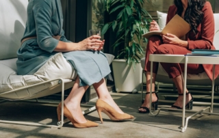 Two women engaged in conversation in a modern office with a professional yet relaxed atmosphere