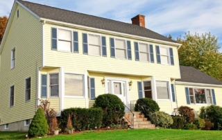 Two-story yellow house with blue shutters