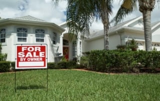 Image of a modern suburban home for sale in florida, featuring a "for sale by owner" sign at the forefront, against a bright, sunny backdrop.