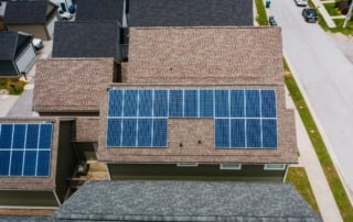 Aerial view of residential buildings with solar panels on rooftops