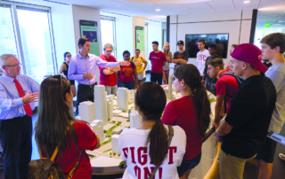 Students examining architectural model for urban planning