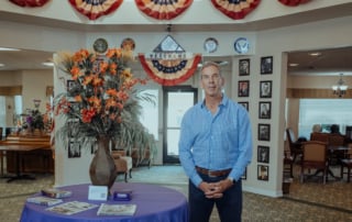 Image of a well-lit lobby interior with a floral arrangement and a person in a blue checkered shirt