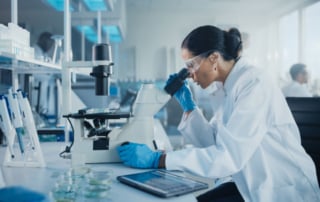 Laboratory setting with person examining sample using a microscope