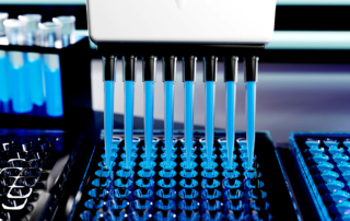 Automated pipettes in action dispensing blue liquid in a lab setting