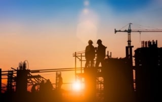 Construction workers in discussion with building and crane