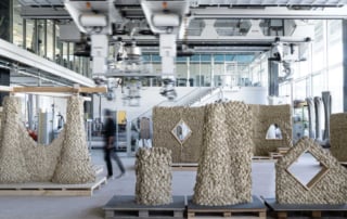 A modern industrial lab showcasing eth zurich's impact printing construction with textured stone-like structures and robotic machinery.