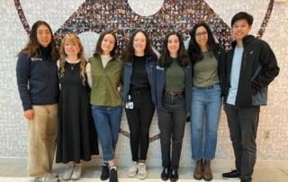 Group of young adults in front of wall mural