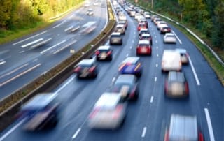 Image of a busy multi-lane highway with several vehicles.