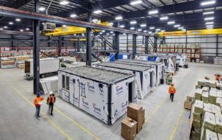 Interior of a large modular manufacturing facility with workers