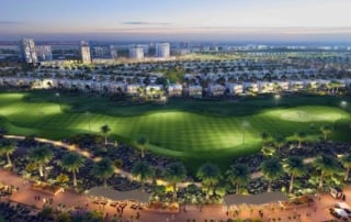 A modern urban development featuring a landscaped golf course, residential villas, and mid-rise buildings in a desert environment, illuminated for evening activity.