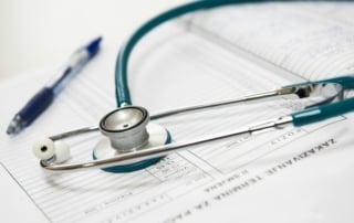 Close-up view of a teal stethoscope on a medical chart with a blue pen, emphasizing healthcare and diagnostics advancements in louisiana.