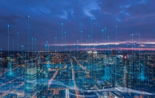 A cityscape at dusk or night with illuminated skyline and digital data overlay representing connectivity and analytics.