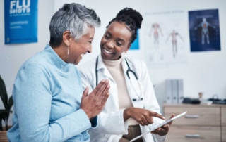 A healthcare professional uses a digital tablet with a patient