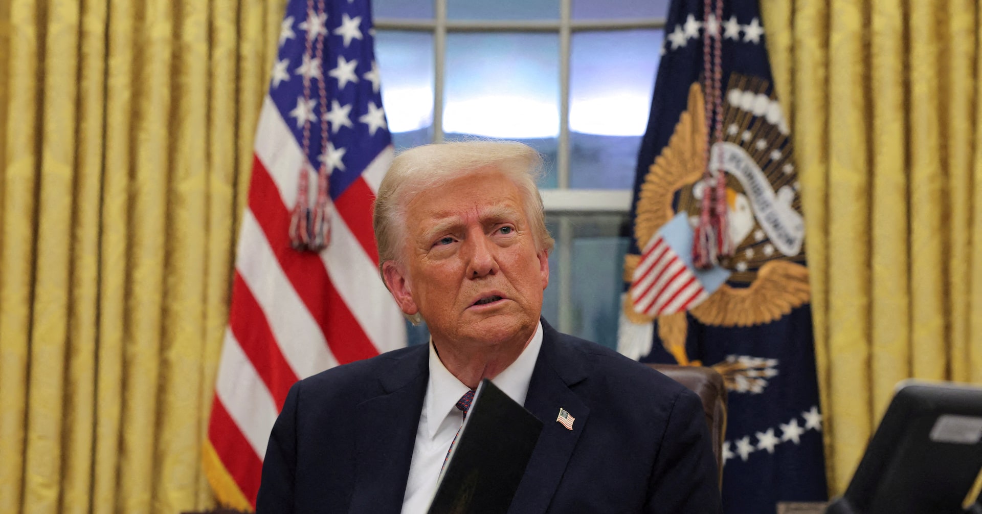 Man in Suit at Desk with American and Eagle-Emblem Flags