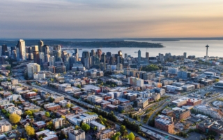 Aerial view of seattle cityscape at sunset, highlighting urban landmarks and natural features.