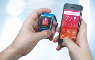 Hands holding a smartwatch and smartphone displaying health monitoring features