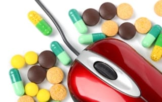 Computer mouse amidst colorful pills highlighting telemedicine's role in healthcare access