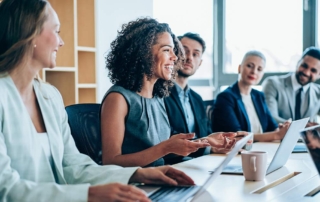 Five professionals seated at a conference table during a meeting.