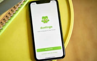 Smartphone displaying duolingo app on yellow surface