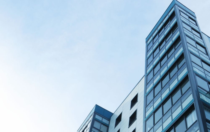 Modern high-rise building with reflective glass windows and sleek design.