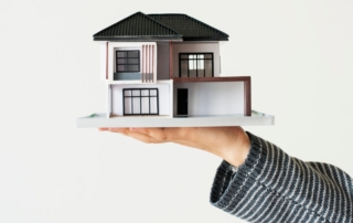 Person holding a contemporary house model