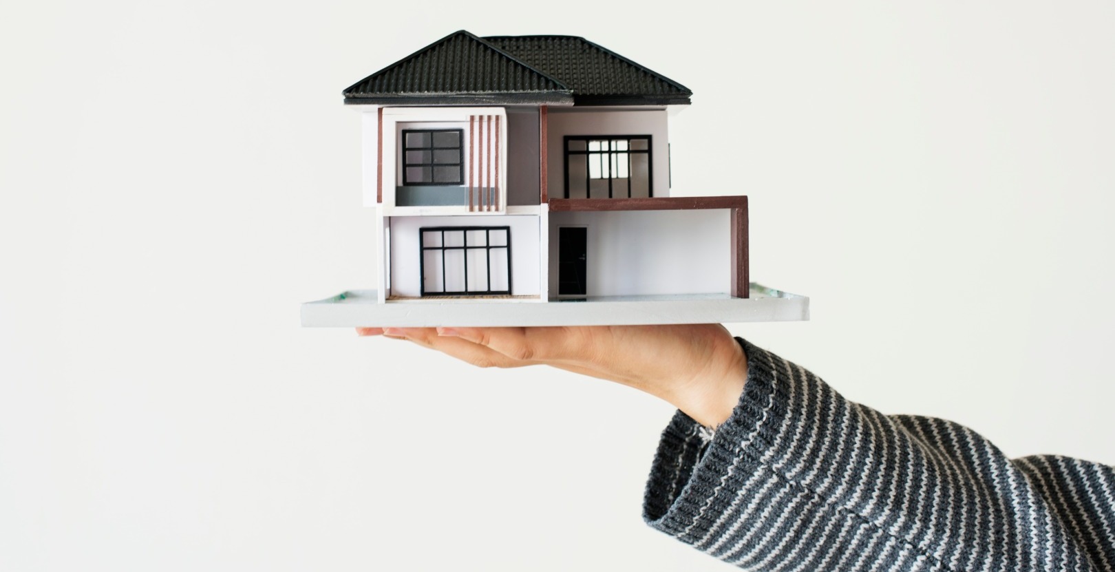 Person holding a contemporary house model