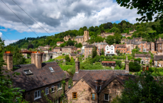 A serene english village with traditional stone houses nestled in greenery, epitomizing the uk's emerging property hotspots.