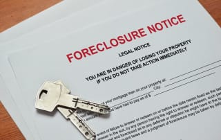 Close-up of a foreclosure notice document with keys on a wooden surface
