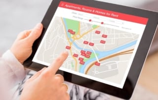 Person using tablet to view real estate rental app map