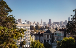 Scenic view of san francisco cityscape with victorian-style houses and modern skyline.