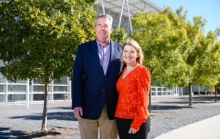 Skip and mitzi gardiner standing outside a modern building on a sunny day