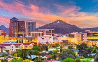 A dramatic sunset over an arizona cityscape with diverse architecture and a mountain "a".