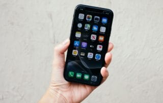 Person holding smartphone displaying app grid