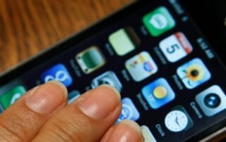 Close-up of an older smartphone model displaying app icons