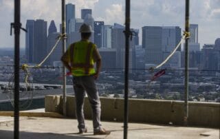 Image of construction site with worker at high-rise building edge
