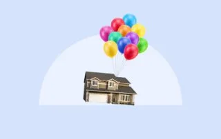 Floating house held aloft by colorful balloons against a light blue sky.