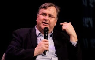 Image of a person speaking into a microphone at an event