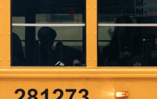 Side view of a yellow school bus with passengers