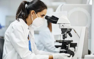 Lab technician in a laboratory using a microscope