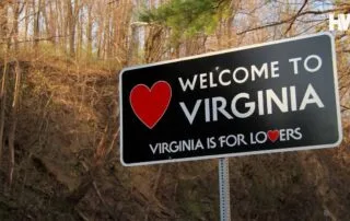 A road sign with 'welcome to virginia' and 'virginia is for lovers,' featuring a red heart symbol.