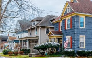 Colorful historic houses in a residential neighborhood during winter with light snow on the ground.