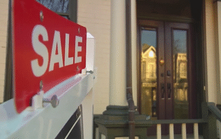 House for sale sign in front of a home’s front door and porch