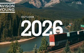 Avison young outlook 2026 cover with a freight train curving along a river through a forested mountain valley.